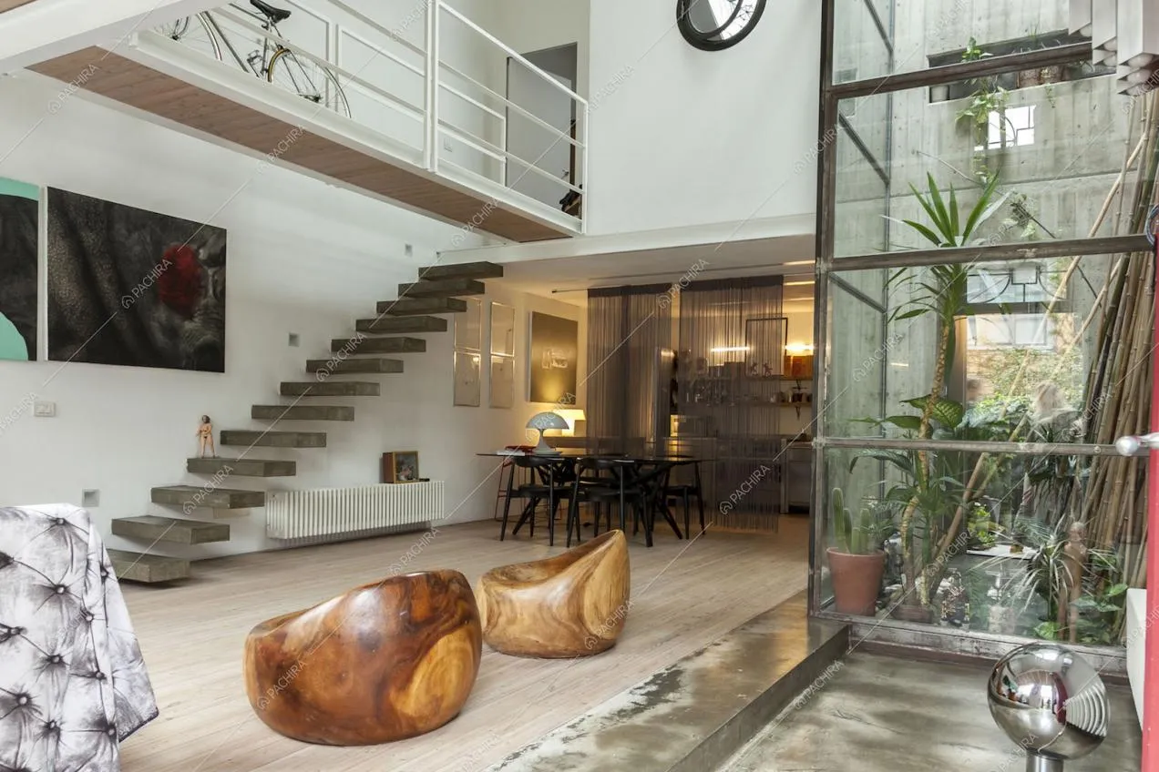 Zona living, giardino d'inverno, poltrone in legno e corridoio sopraelevato