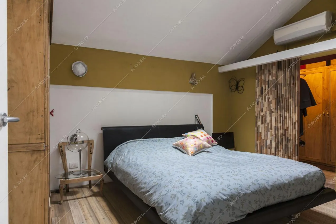 Camera da letto nel sottotetto con scorcio del guardaroba