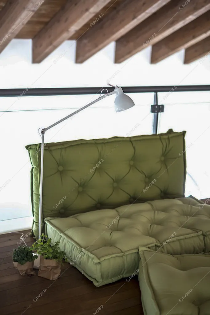 Divanetto verde sul pavimento in parquet