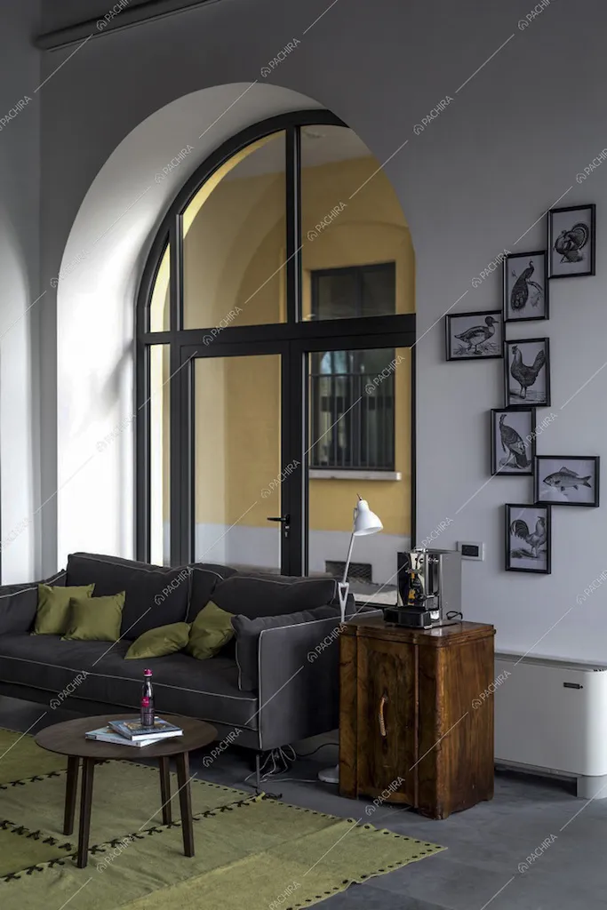 Divano con tavolino, comodino e vetrata ad arco