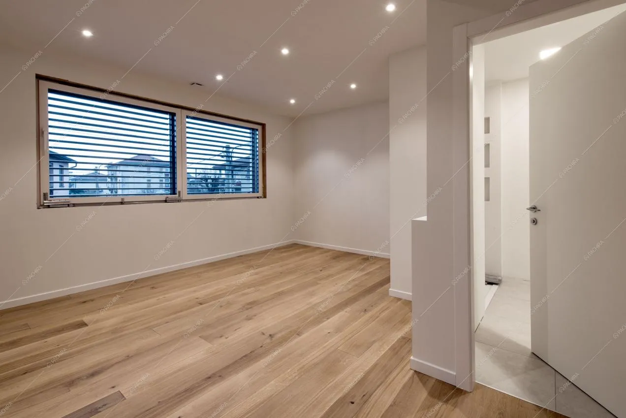 Spazio libero con pavimento in parquet a listoni e finestre