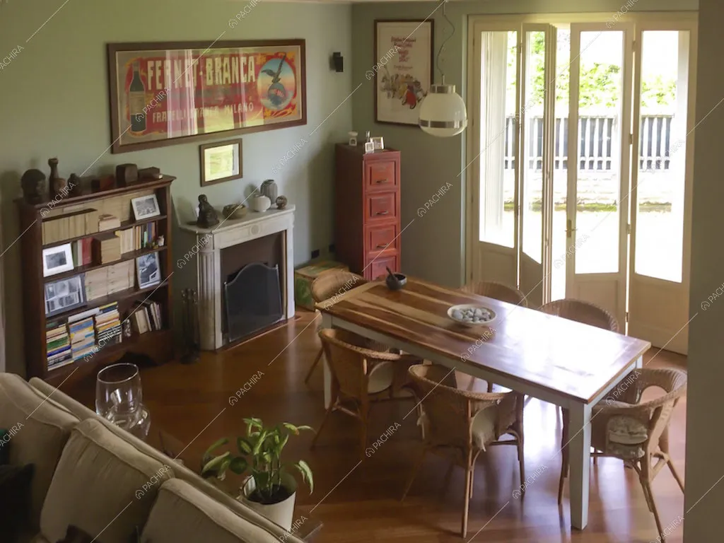 Zona pranzo con tavolo in legno da sei posti e sedie in vimini, porta finestra