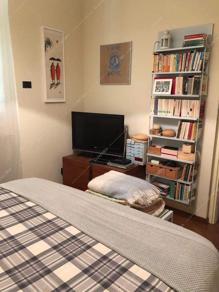 Libreria sospesa e televisore nella camera da letto