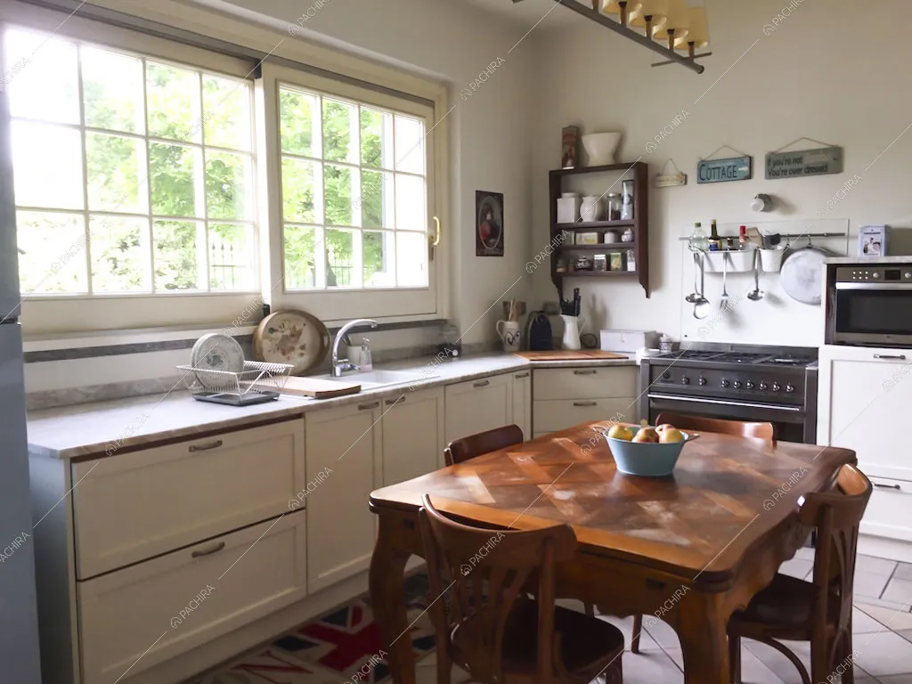 Cucina a parete bianca e tavolo da pranzo in legno