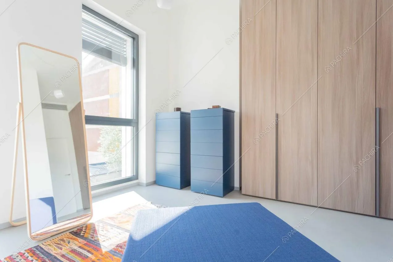 Pouf e armadietti blu nella cabina armadio dagli armadi in legno