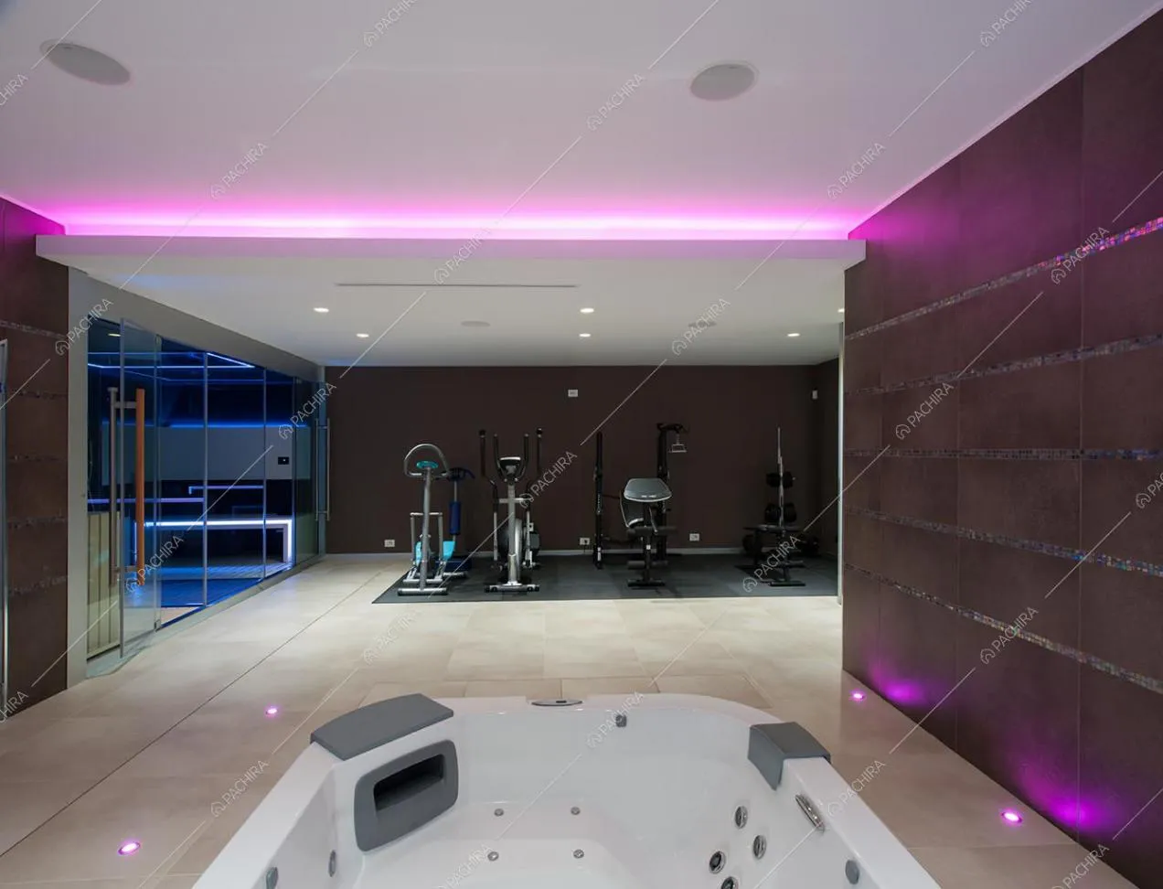 Palestra con illuminazione fucsia e vasca idromassaggio