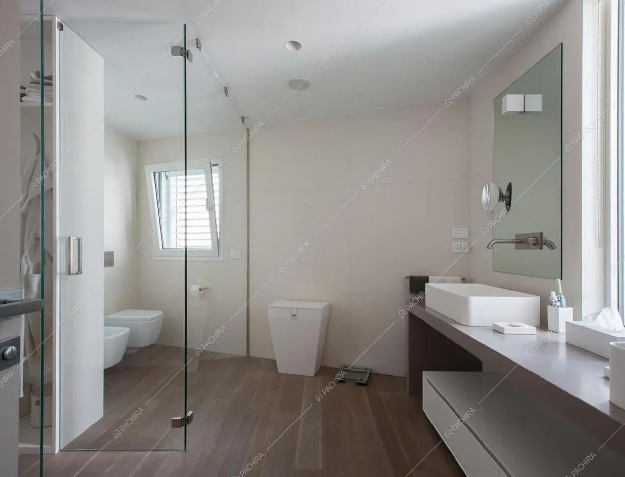 Bagno con pareti bianche o in vetro e sanitari sospesi