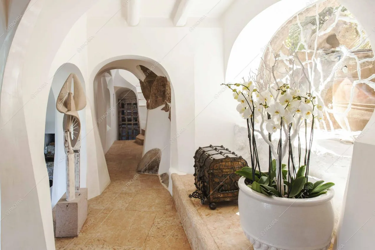 Corridoio con pavimento in pietra e soffitto bianco con archi