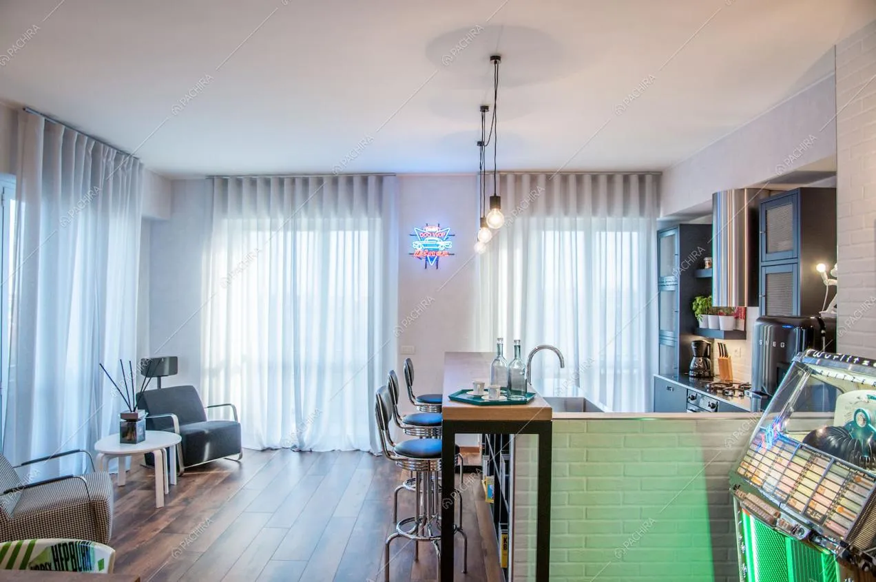 Zona living con poltrone di design e pavimento in parquet a listoni