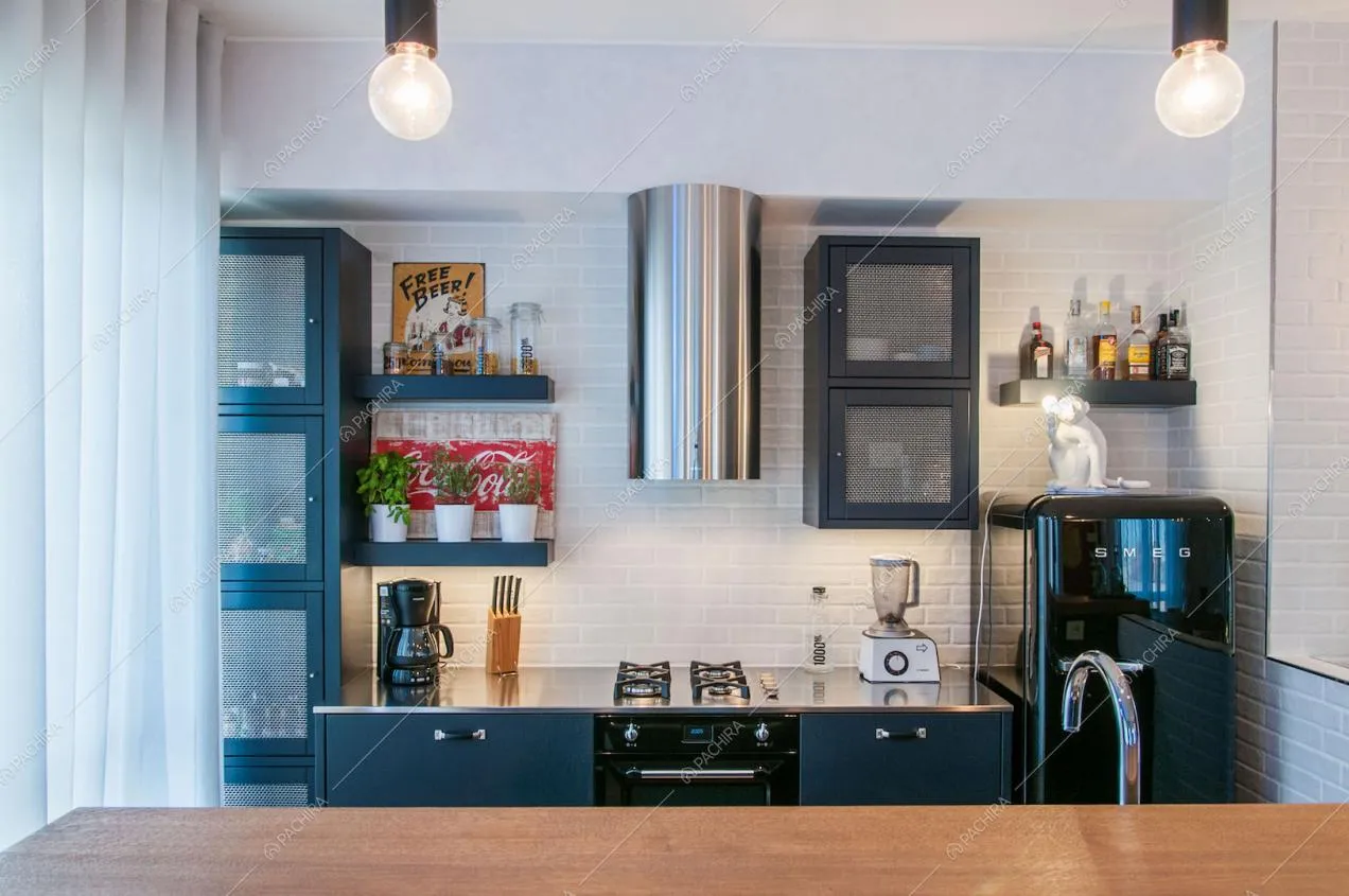 Cucina con fornelli a gas e banco bar con piano di lavoro in legno