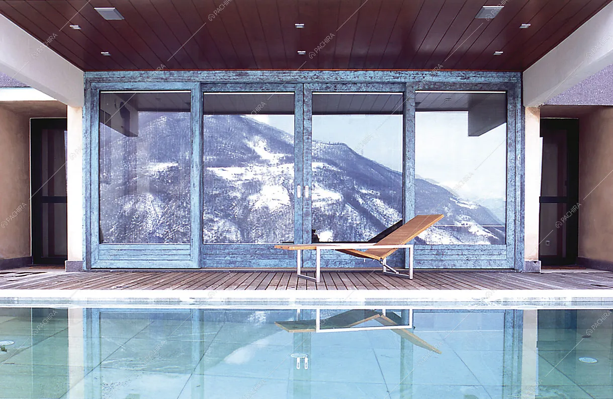 Piscina e riflesso delle montagne sulla vetrata