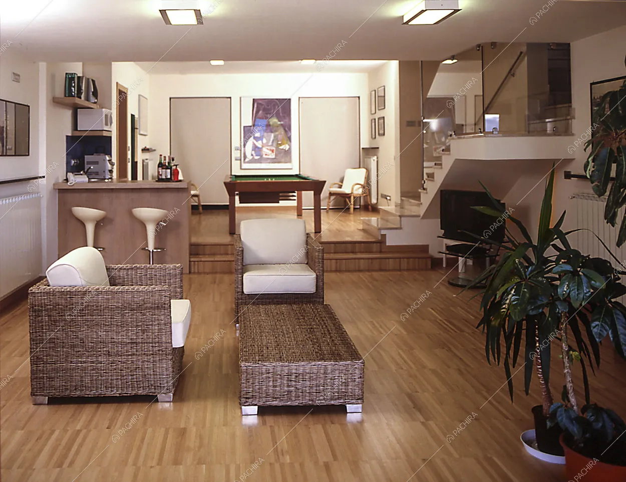 Zona relax con poltrone in vimini e biliardo
