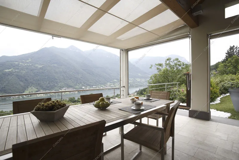 Terrazza con tavolo da pranzo in legno e vista lago