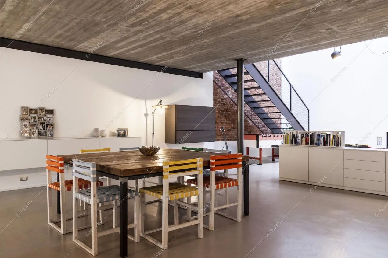 Tavolo da pranzo quadrato in legno e vista sulle scale