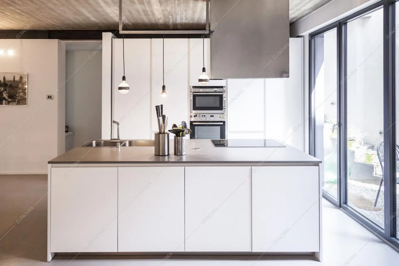 Cucina con armadi bianchi e pavimento in cemento lisciato