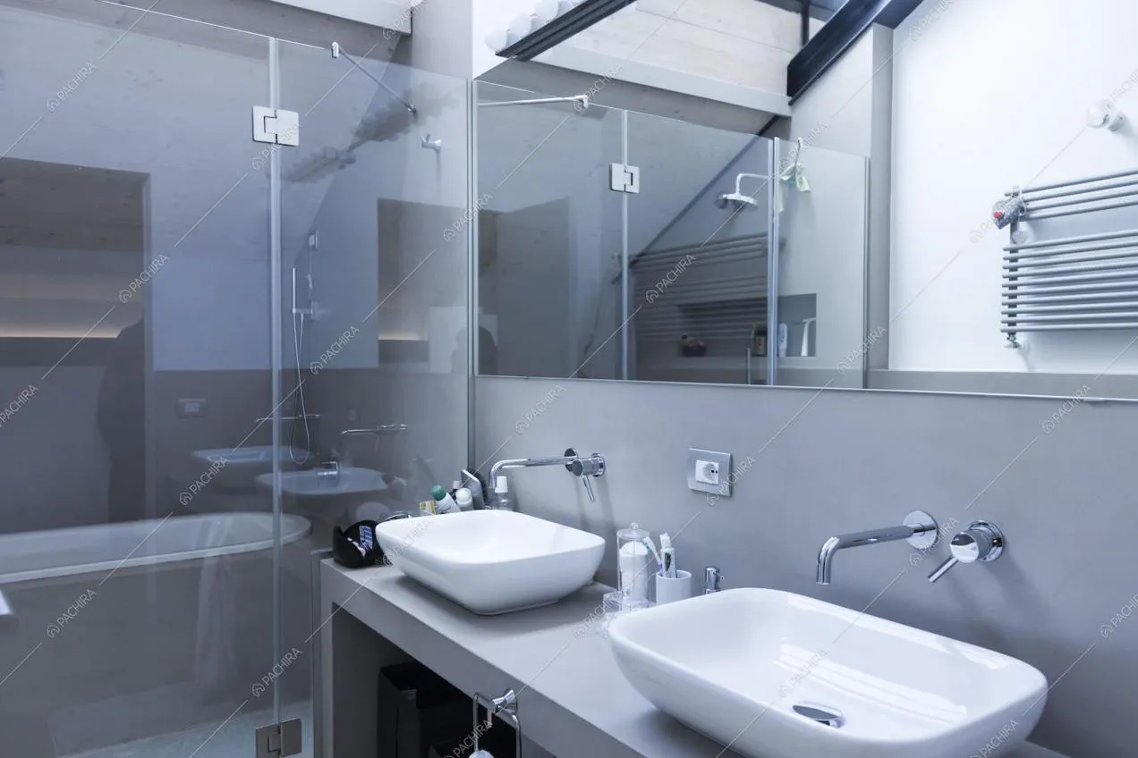 Bagno grigio minimal con due lavandini e grande specchio