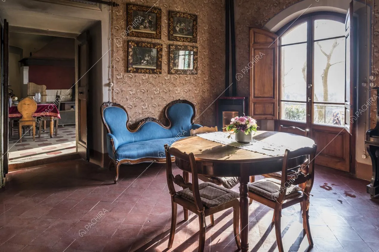 Sala da pranzo con pavimento in cotto rosso e divano d'epoca indaco