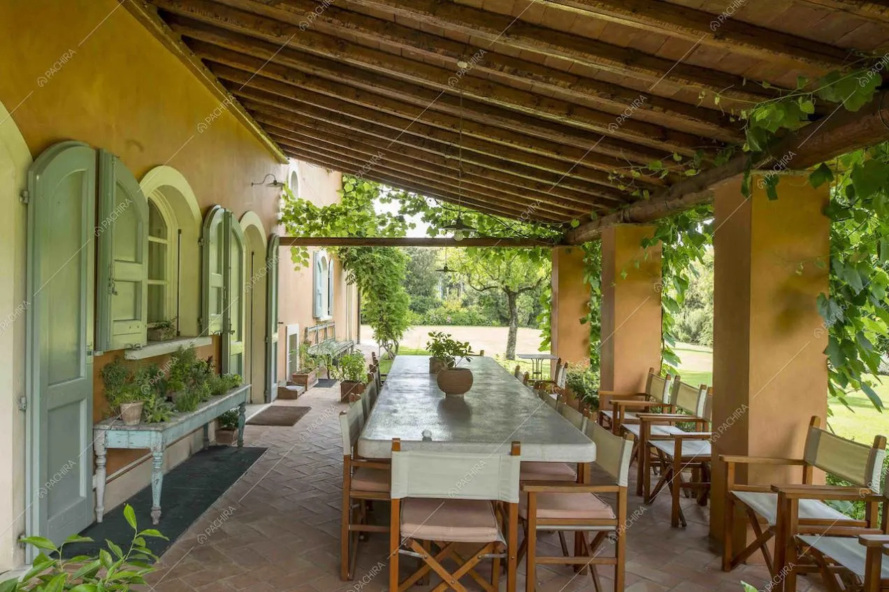 Patio con travi in legno a vista e grande tavolo da pranzo