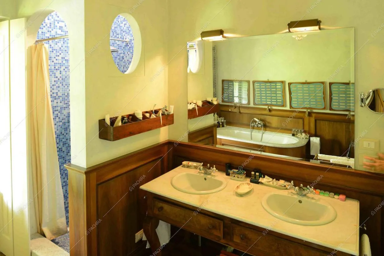 Bagno con due lavandini e scorcio sulla doccia con piastrelline di sfumature di blu
