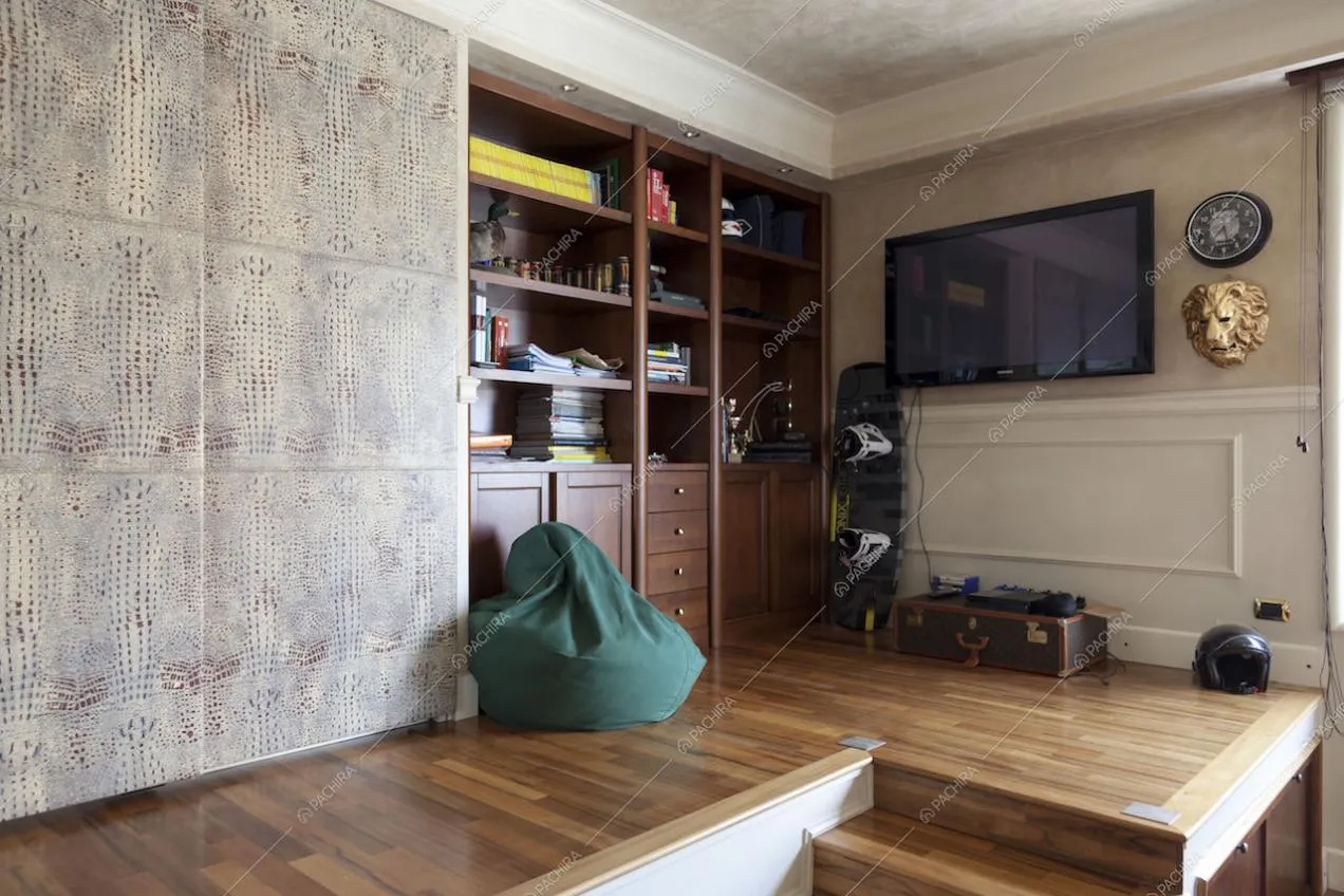 Zona relax rialzata con libreria, pouf e tv