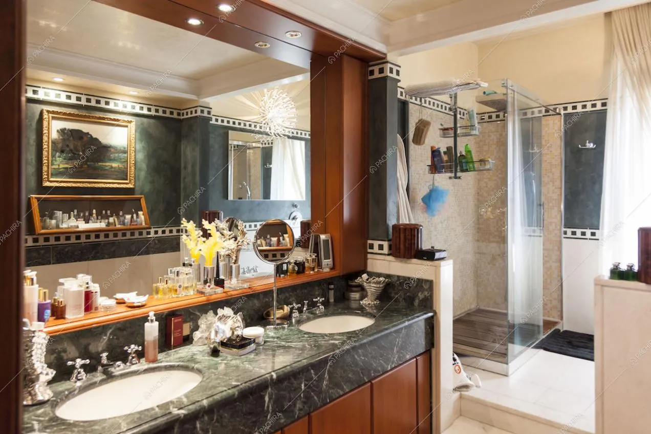 Bagno in marmo e in legno con ampio specchio