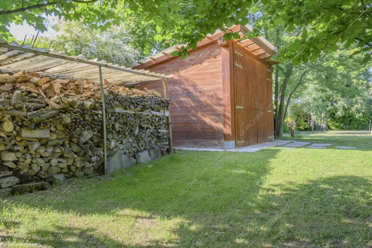 Legna accatastata sotto una tettoia di fianco al garage