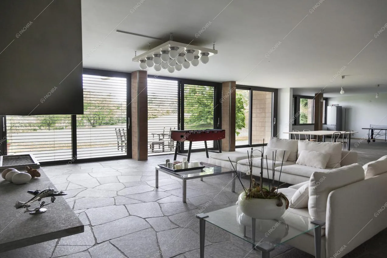 Vista dello spazio con zona living, tavolo da pranzo e tavolo da ping pong