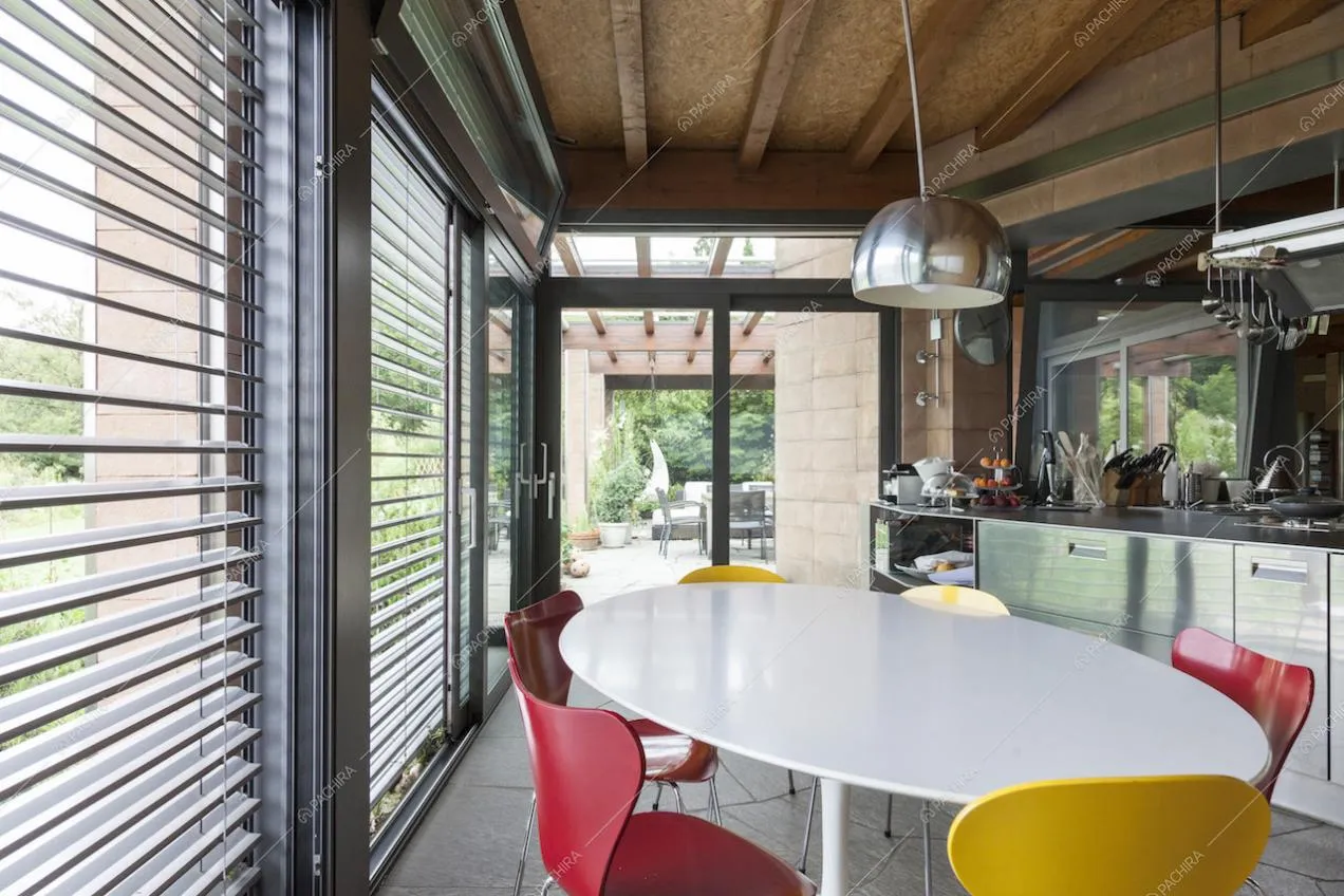 Tavolo da pranzo con sedie colorate in cucina e vista sull'esterno