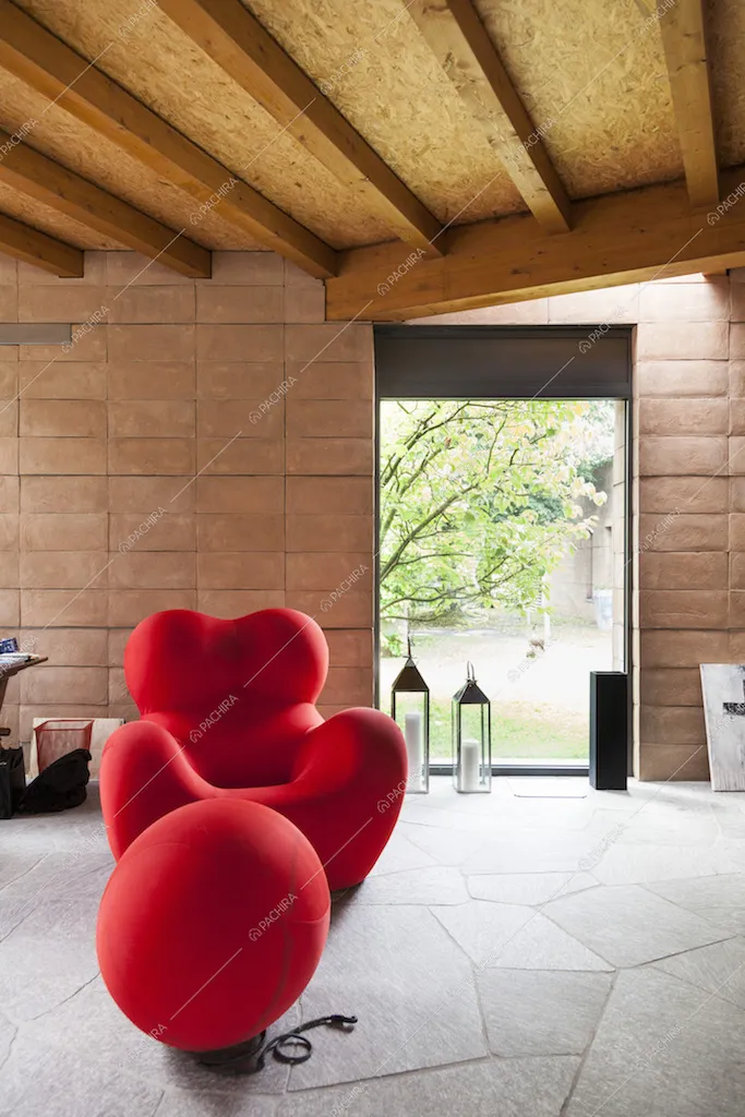 Poltrona rossa di design e vetrata nella zona living