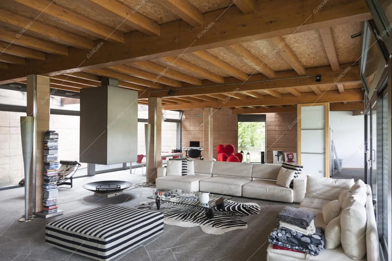 Zona living con pavimento in pietra, travi a vista