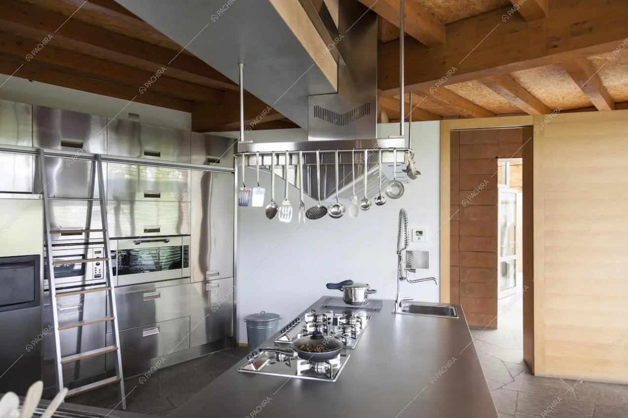 Cappa in acciaio con appesi utensili da cucina