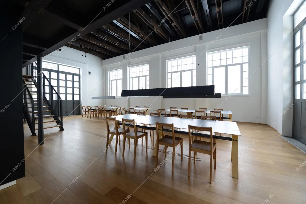Sala con quattro tavoli, vetrate e travi a vista