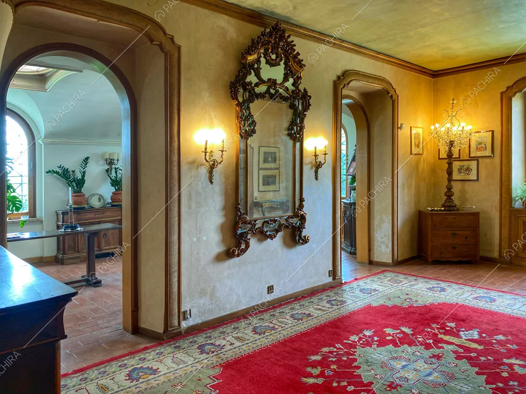 Atrio con pareti e soffitto beige con boiserie, cassettiere e vista sulla sala