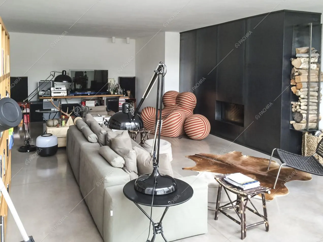 Zona living con divano, poltrona di design e camino