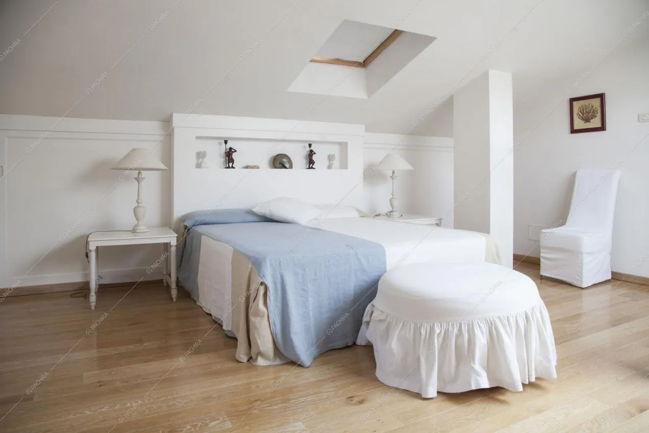 Camera da letto matrimoniale con pouf e lucernario