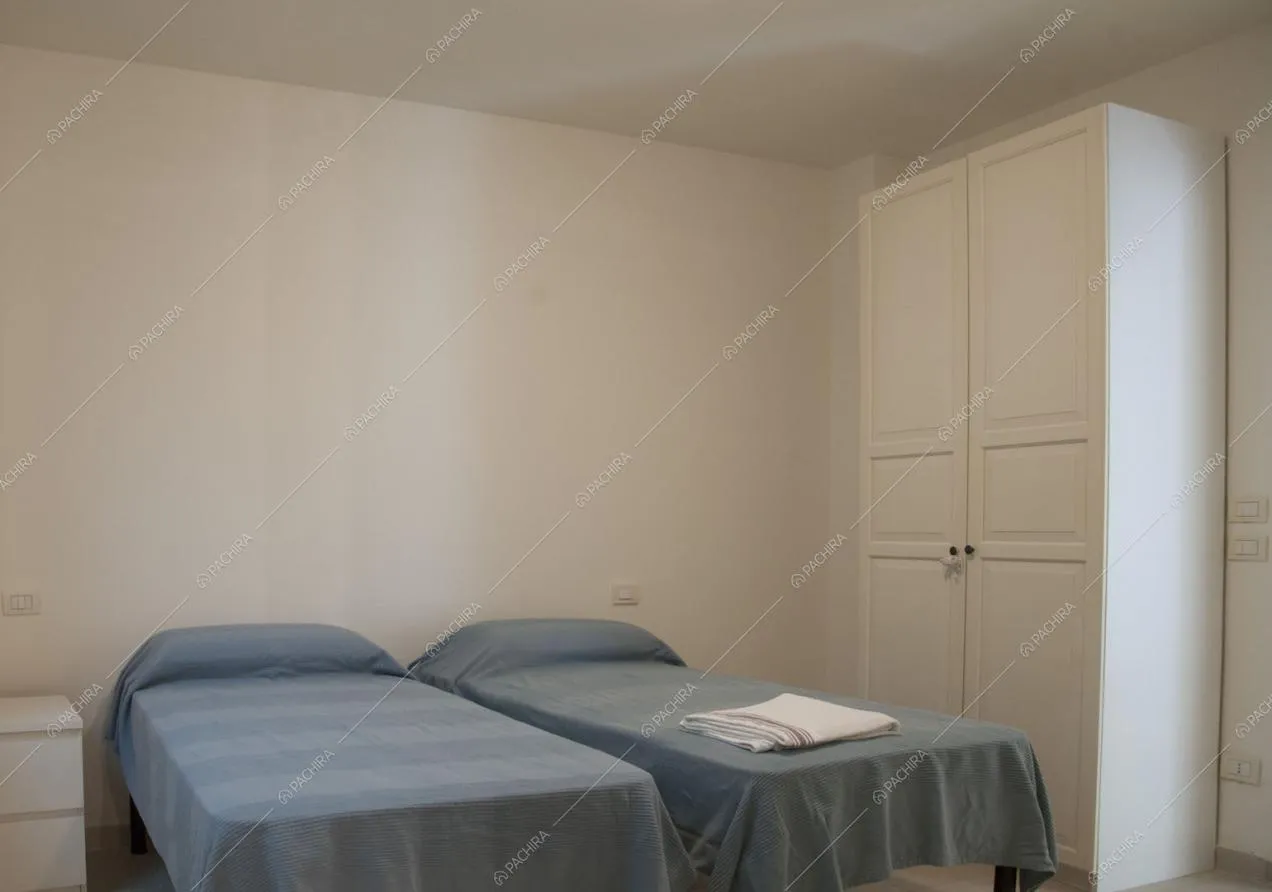 Due letti singoli e armadi bianchi