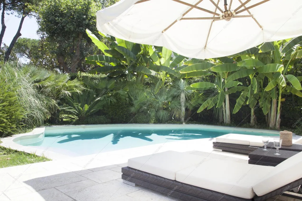 Zona piscina con sdraio e tavolino