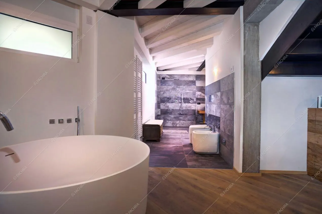 Sanitari con pavimento in pietra e travi a vista