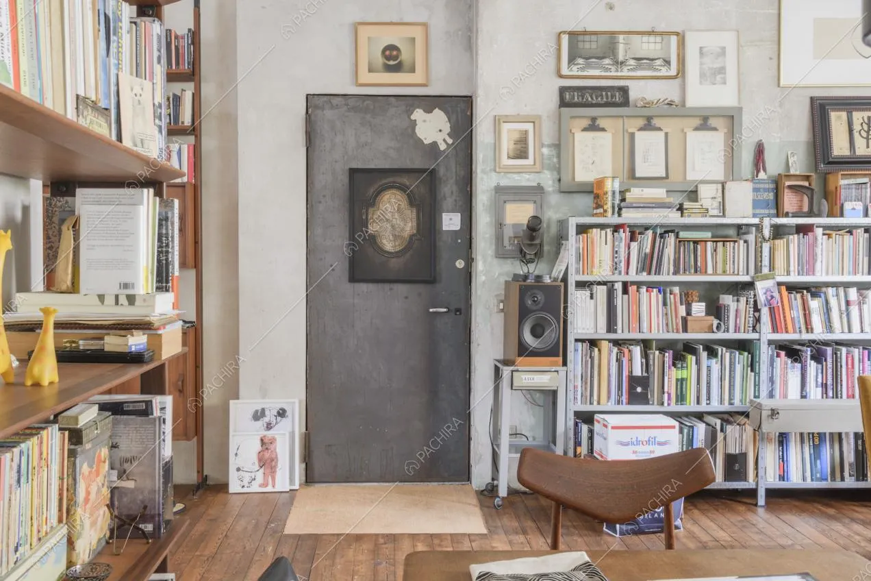 Ingresso nella zona giorno con librerie lungo le pareti