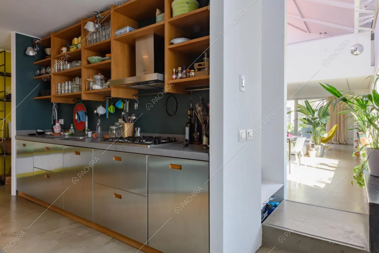 Vista sulla zona living nella cucina a parete in acciaio con fornelli a gas