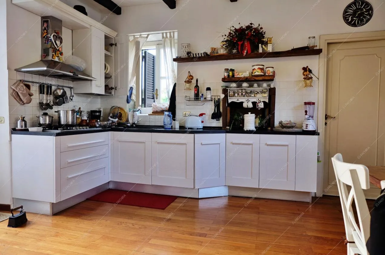 Cucina bianca a parete e parquet a listoni