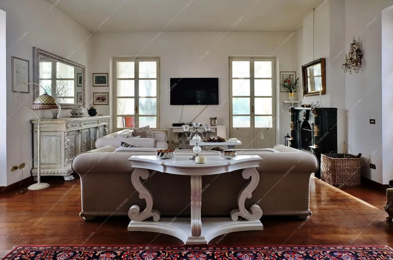 Zona living  con pavimento in parquet, camino e mobili d'epoca