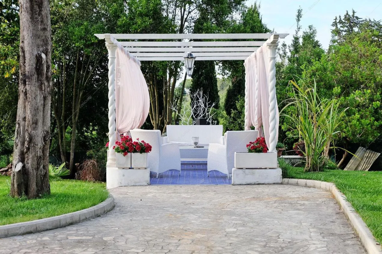 Selciato che porta al gazebo con divanetti in vimini