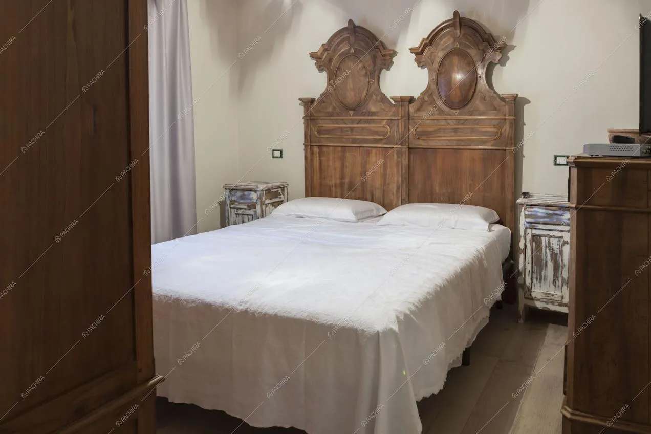 Camera da letto matrimoniale con testata in legno intagliato