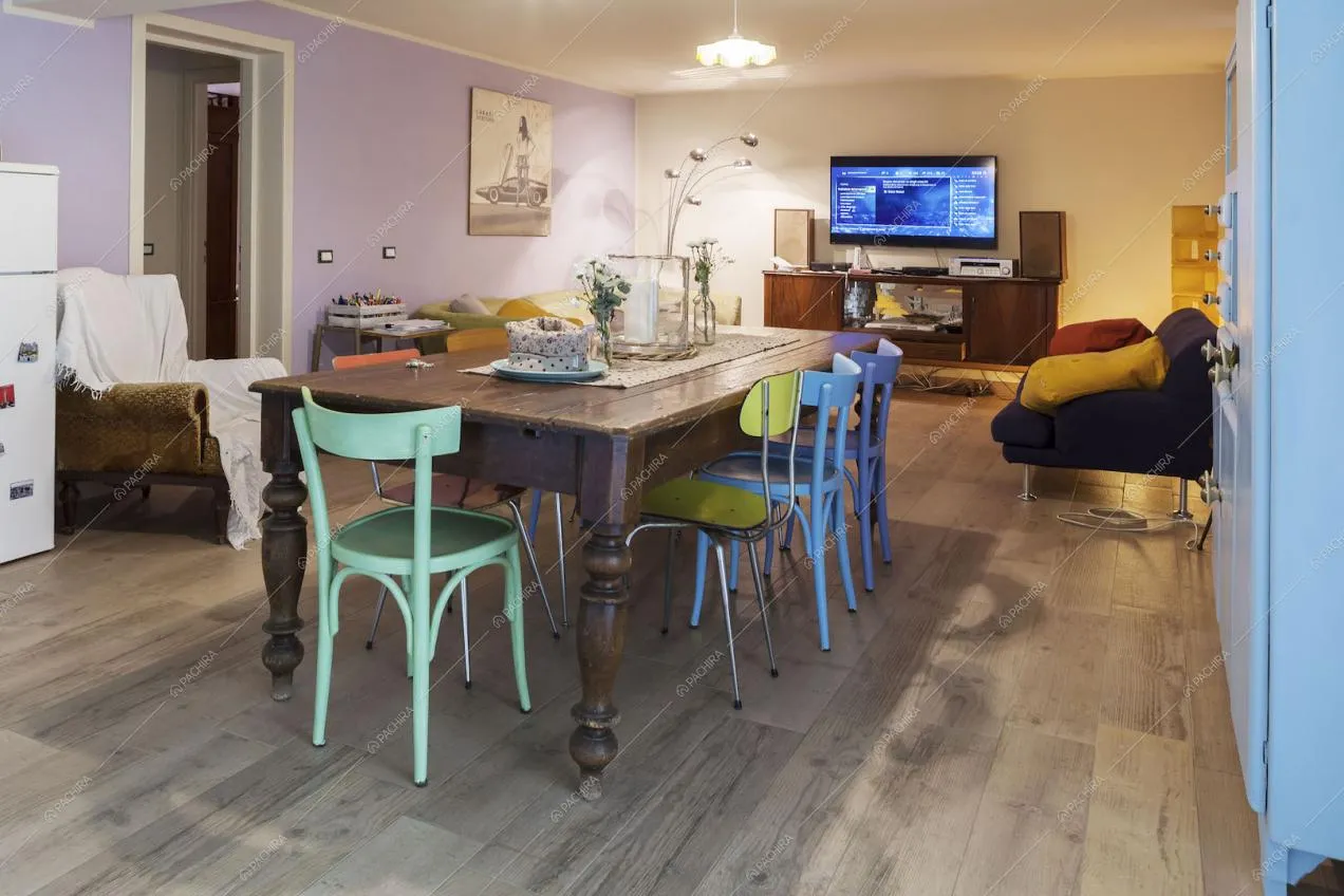 Sala con tavolo da pranzo in legno e pareti viola e bianca