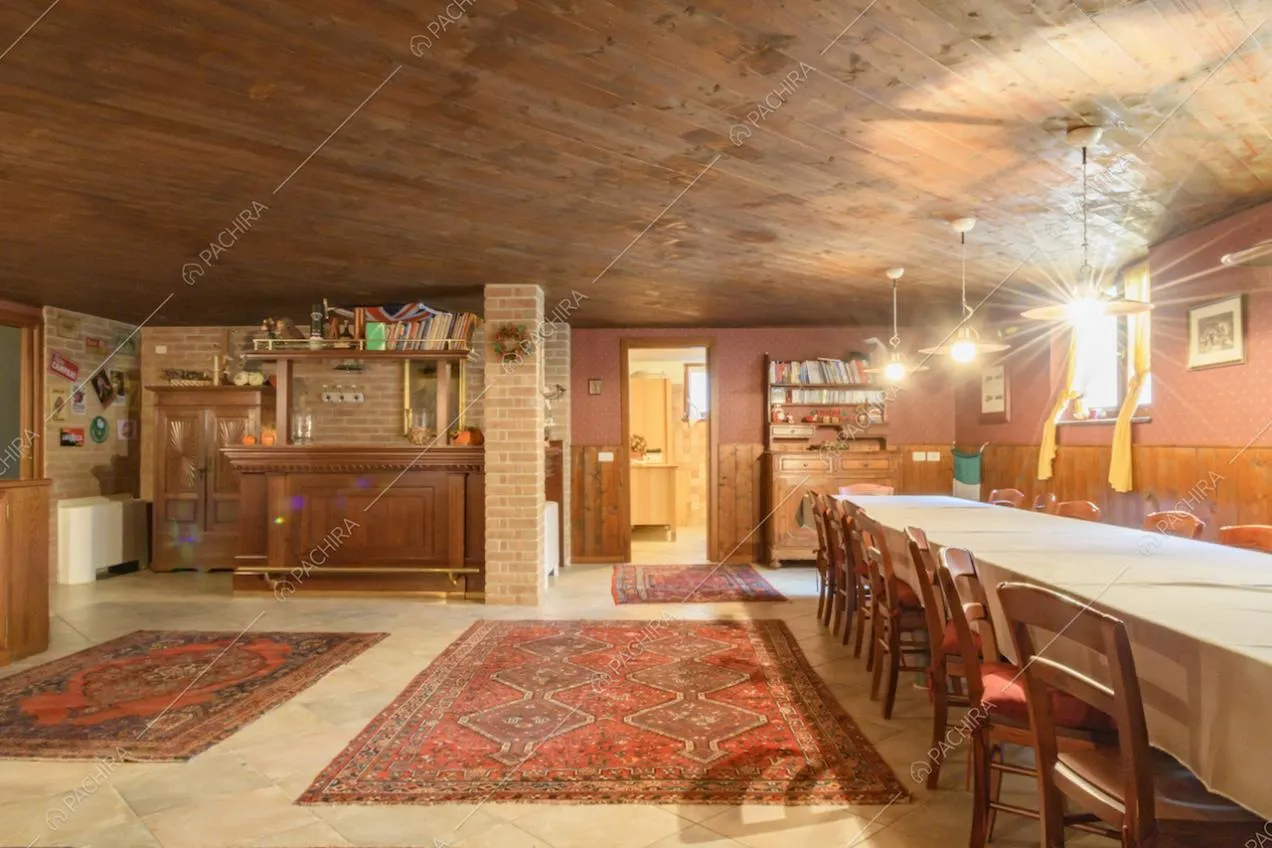 Sala da pranzo con angolo bar, boiserie in legno e tappeti