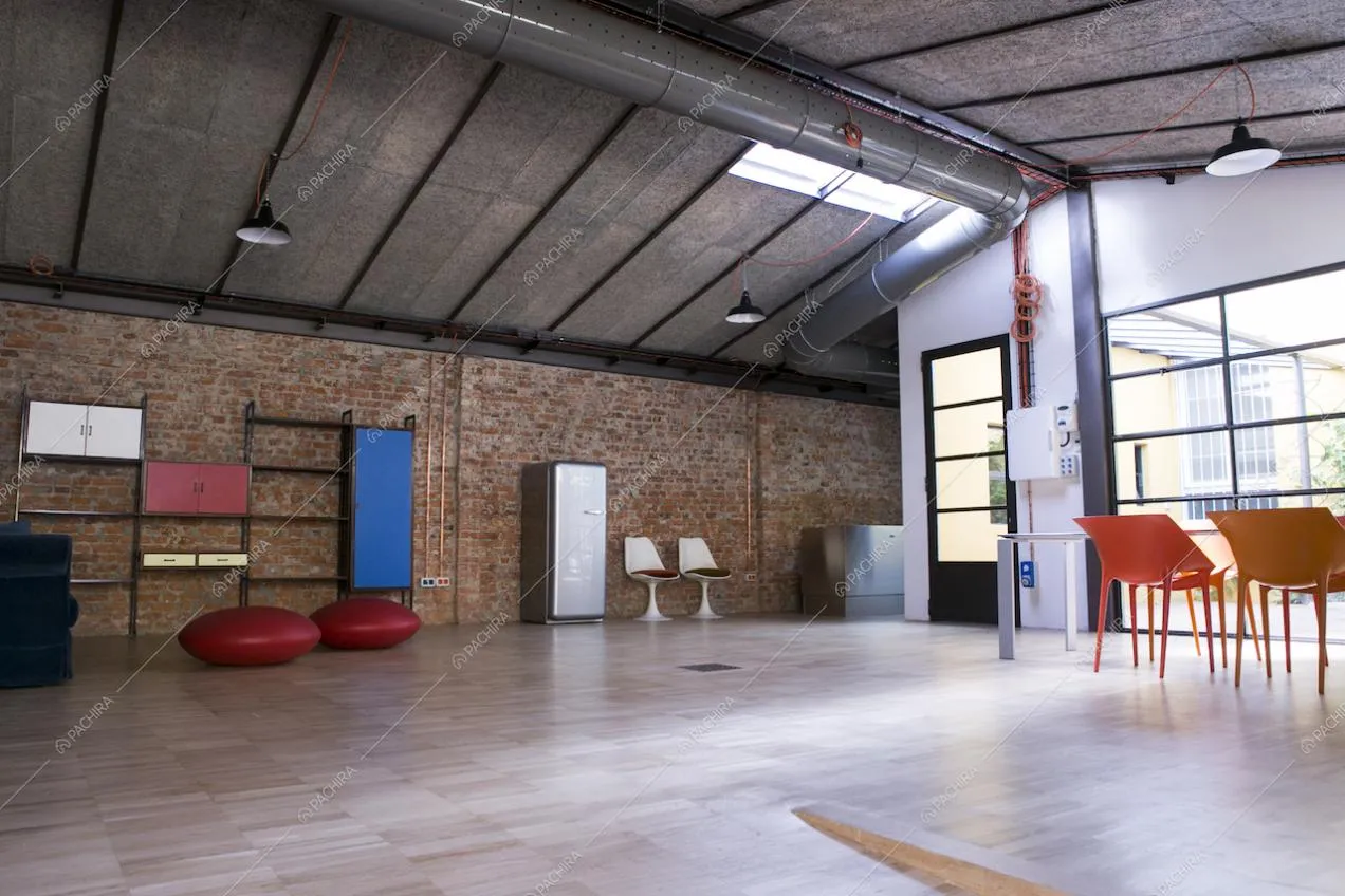 Open space in stile industriale con pareti in mattoni rossi