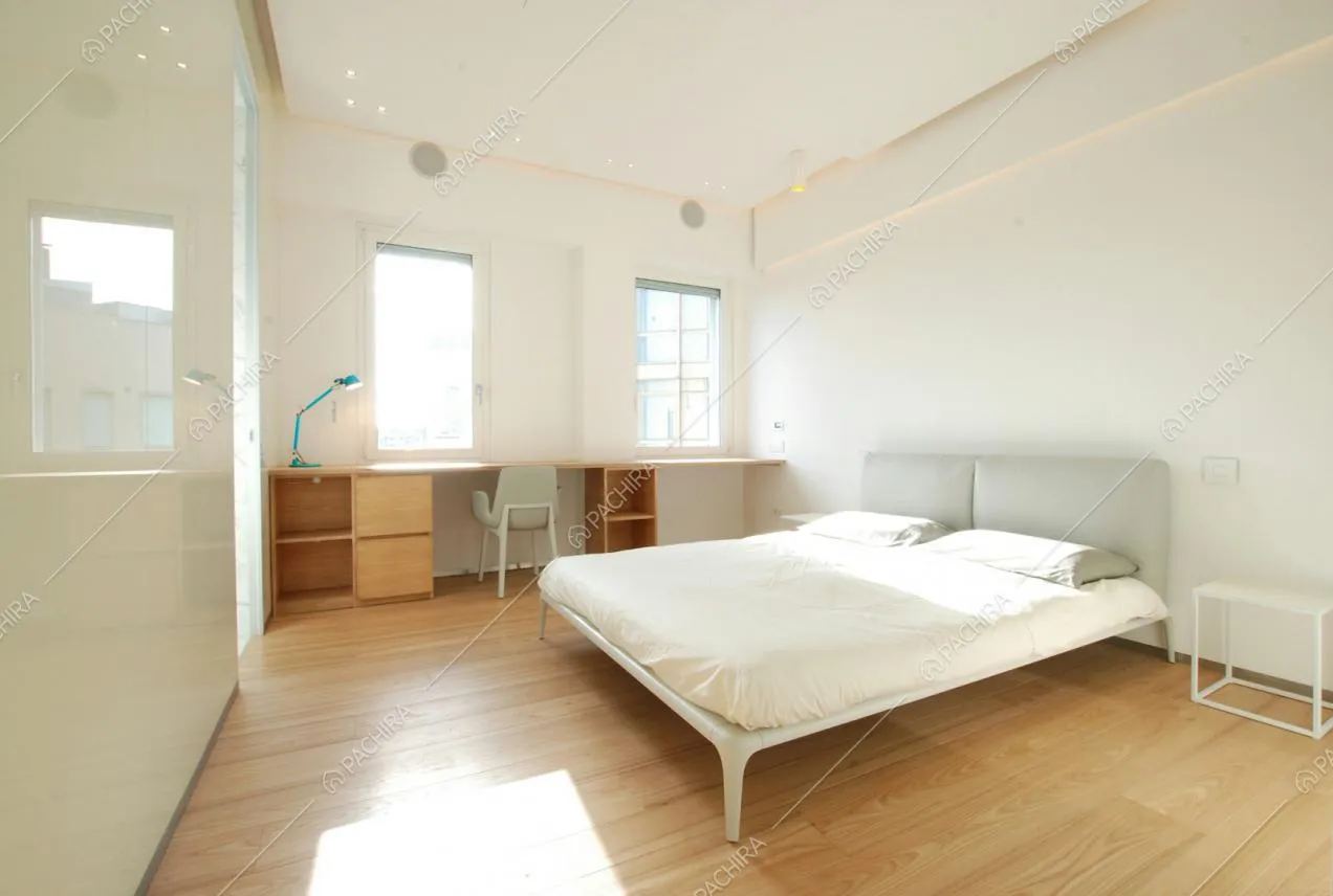 Camera da letto bianca con pavimento in legno