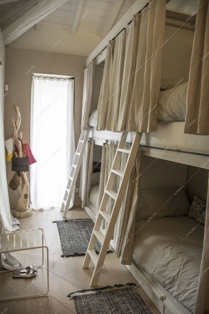 Letto a castello con tende bianche e scalette