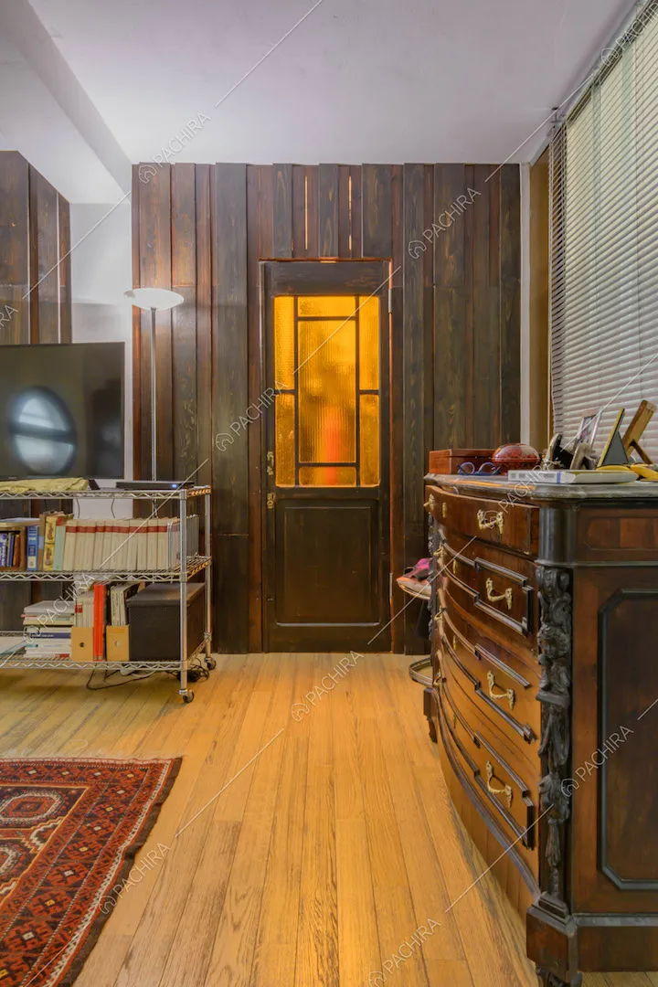 Pavimento in parquet nella luminosa camera da letto matrimoniale con pareti in legno